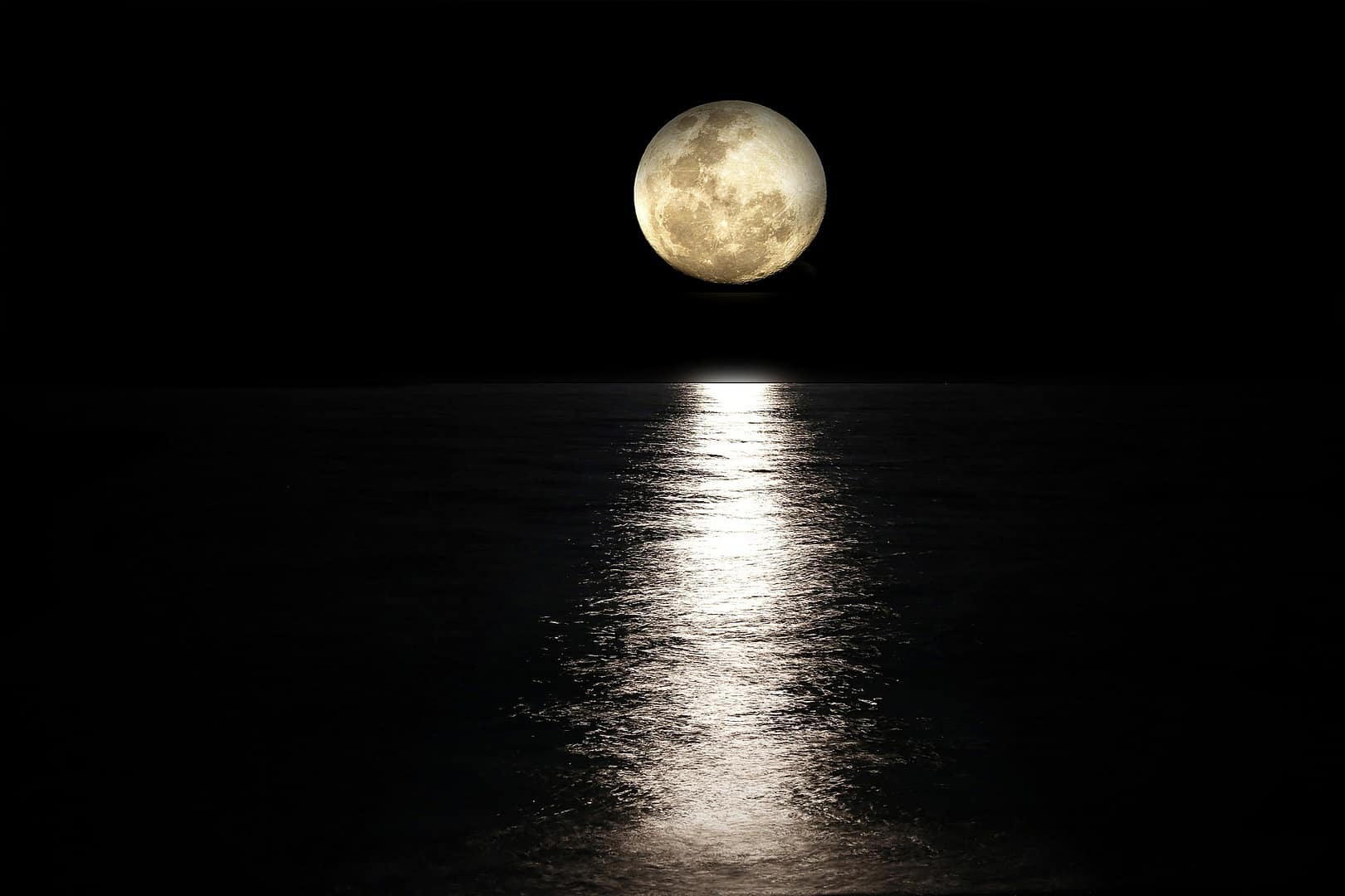 Moon over water at night
